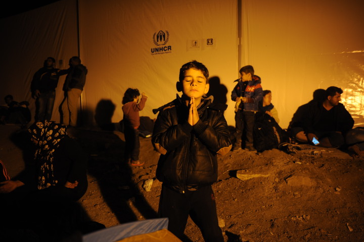 October 4, 2015 - Lesvos, Greece: Child prays in a temporary shelter of the island, where, every day arrive thousands of refugees from the turkish coasts on plastic, small boats. ( Maro Kouri)