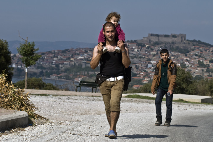 October 4, 2015 -Lesvos, Greece: man and child have just arrived by a plastic boat to the Greek coast, from Turkey, and walk all the way to find a camp near Molyvos city (Maro Kouri)