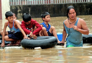 A flooded poor riverside community in Manila – risks are interconnected
