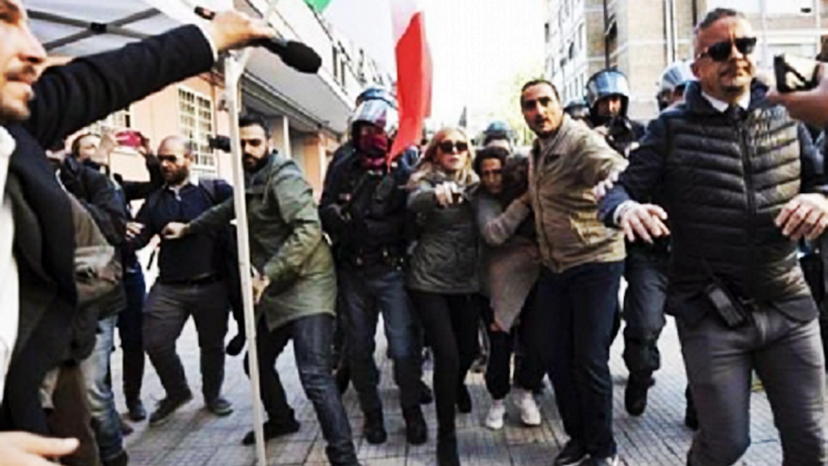 Suzana e la piccola figlia scortate dalla Polizia per entrare nella loro casa.