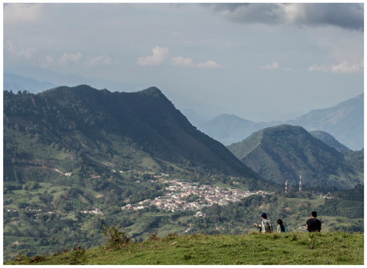 Los hermanos Jorge y Wilson Arboleda Rúa contemplan con Ana Belén, hija de Wilson, la cabecera municipal de Pueblorrico desde un terreno aledaño al sitio donde ocurrió el ataque.