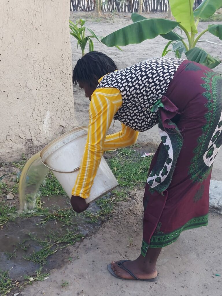 Precious waters the garden in her backyard