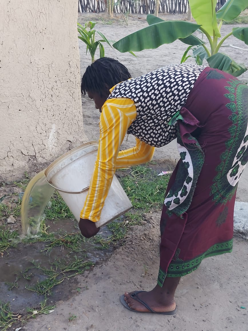 Precious waters the garden in her backyard