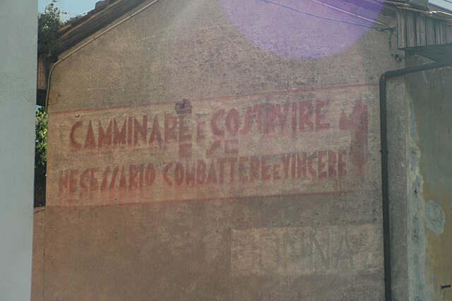 scritta sul muro di Donnaz: CAMMINARE E COSTRUIRE E SE NECESSARIO COMBATTERE E VINCERE