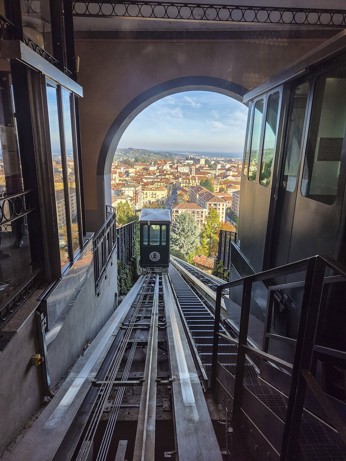 Immgine dell' ex funicolare di Biella con le due cabine e la veduta sulla città dalla stazione del Piazzo
