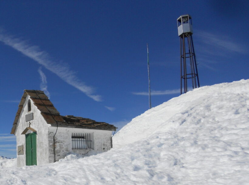 Cima innevata del Monte Camino (Biella) con chiesetta e struttura metallica