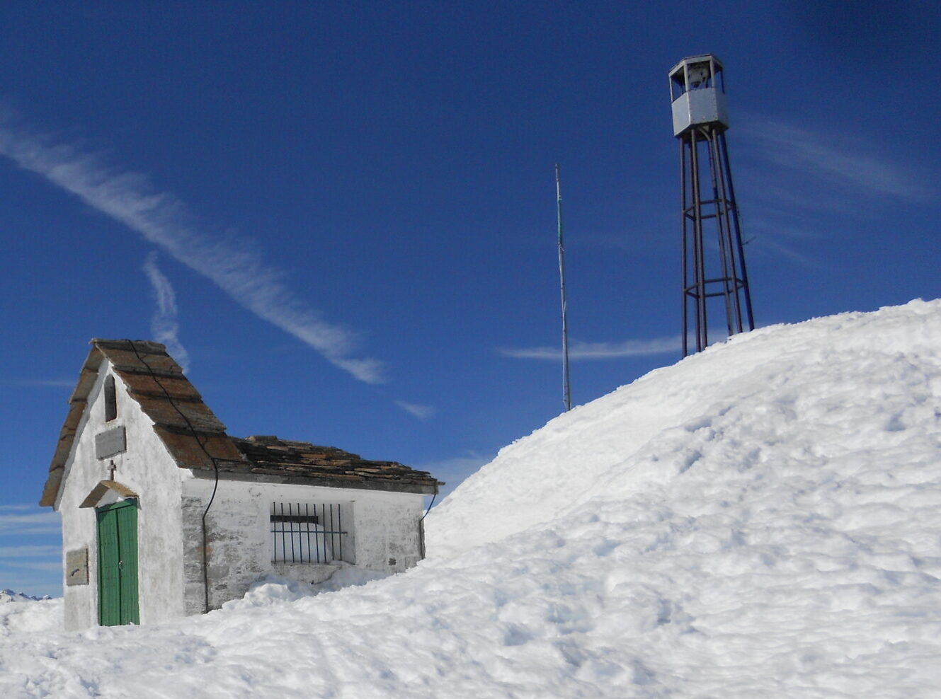 Cima innevata del Monte Camino (Biella) con chiesetta e struttura metallica