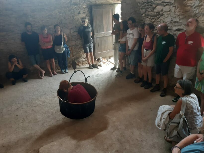 Leo Romano legge dentro al paiolo appeso al soffitto il libro di Muin Masri Vendesi croce