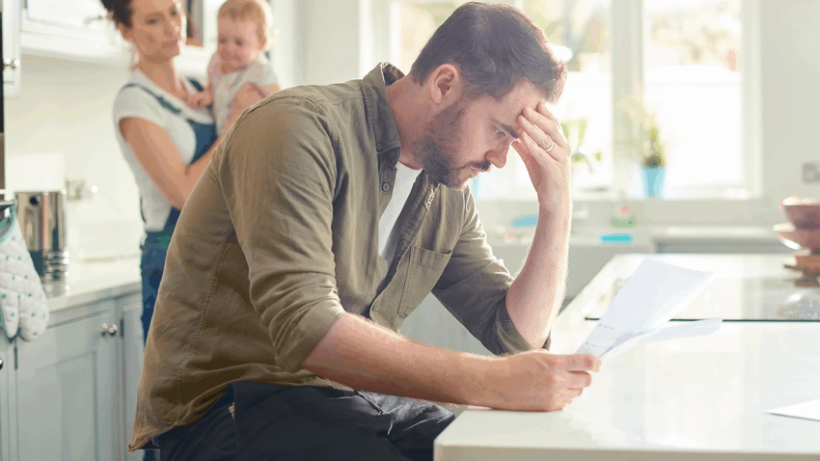 Un signore che guarda una bolletta da pagare