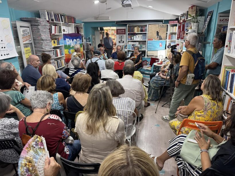 Sala gremita della Libreria IoCiSto a Napoli durante l’Eirenefest, con il pubblico che ascolta la tavola rotonda sulla nonviolenza attiva con padre Alex Zanotelli, Giuliana Martirani e Livio Gaio di Pax Christi Napoli.