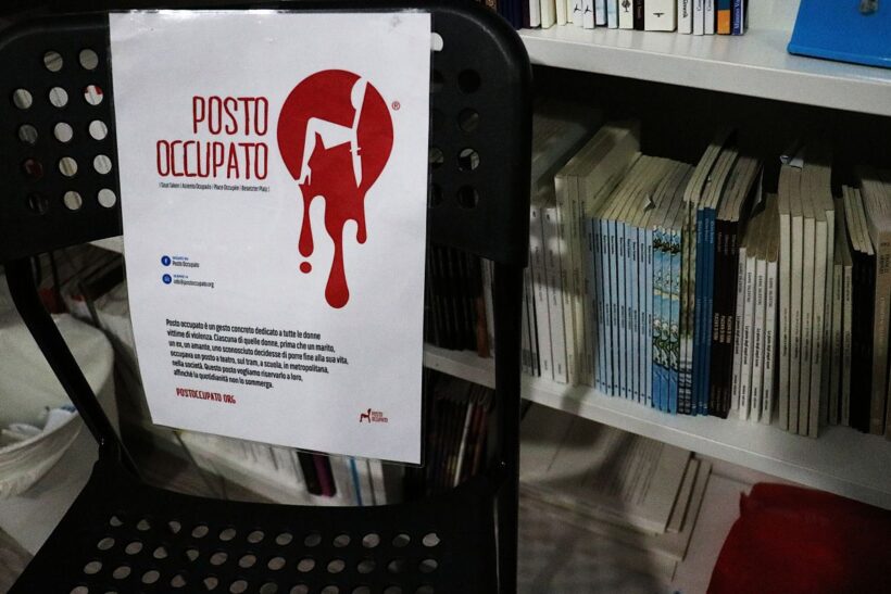 Una sedia vuota con il cartello “Posto Occupato” è collocata davanti agli scaffali della libreria IoCiSto. L’immagine rappresenta simbolicamente lo spazio che sarebbe spettato a una donna uccisa da violenza maschile, come gesto di memoria e responsabilità collettiva nell’ambito della rassegna Memoria Attiva promossa da ANPI Aedo Violante.