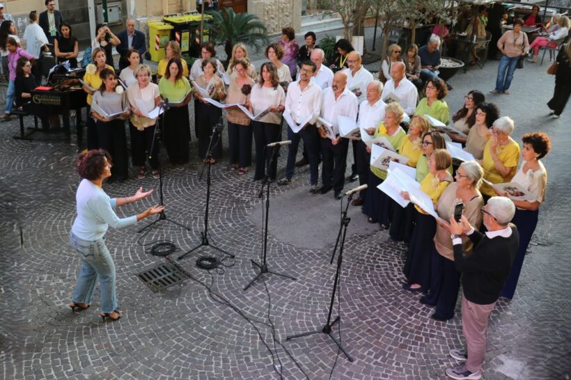 Il coro IoCiSto APS, diretto da Francesca Curti Giardina, durante una performance pubblica a Napoli, in un momento di musica condivisa e partecipata.