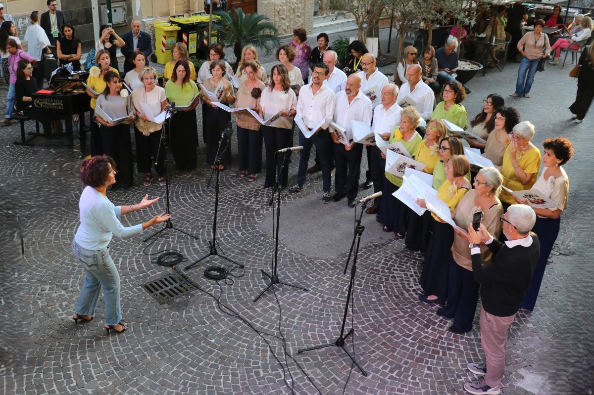 Il coro IoCiSto APS, diretto da Francesca Curti Giardina, durante una performance pubblica a Napoli, in un momento di musica condivisa e partecipata.
