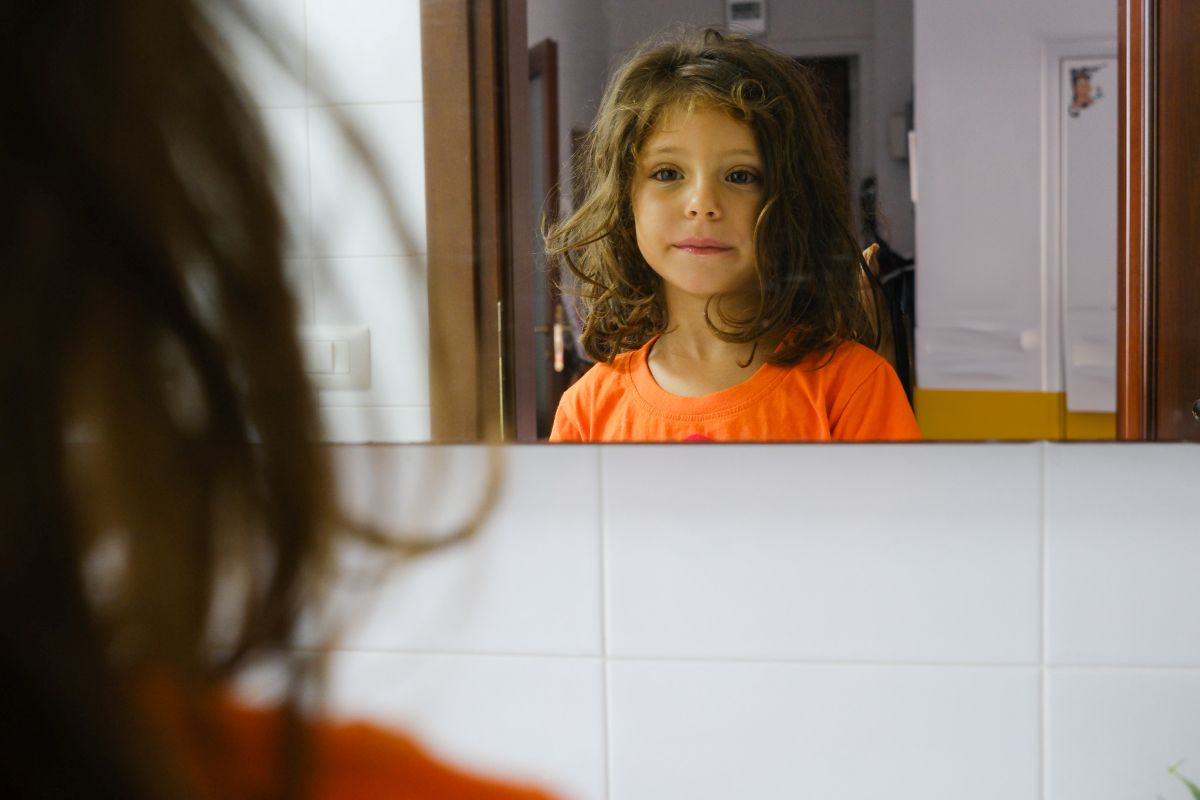 Dede si lava i denti davanti allo specchio, nella sua casa a Napoli. Un gesto semplice e quotidiano, dentro uno spazio protetto. Dal progetto Between Gaza and Naples. A Childhood Story.