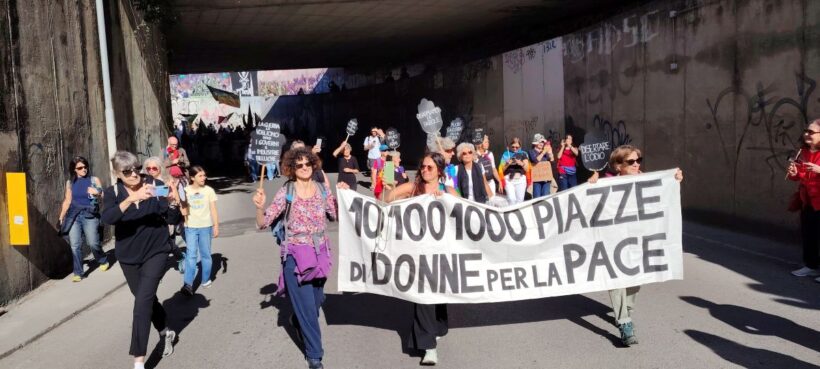 Un momento della mobilitazione “10, 100, 1000 Piazze di Donne per la Pace”: donne in marcia con lo striscione del movimento durante una manifestazione pubblica contro guerra, riarmo e militarizzazione.