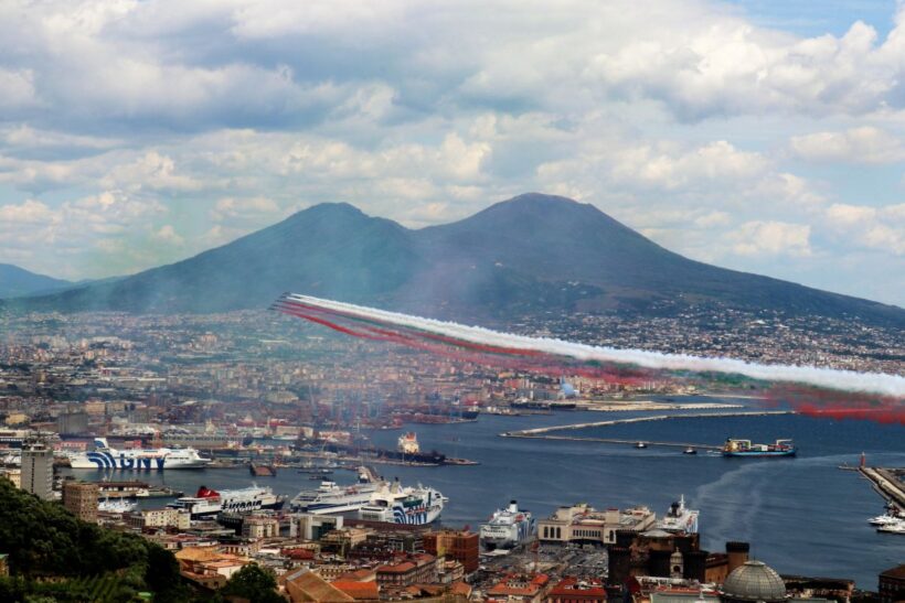 Le Frecce Tricolori sorvolano il golfo di Napoli lasciando in cielo i colori della bandiera italiana, con il Vesuvio sullo sfondo.
