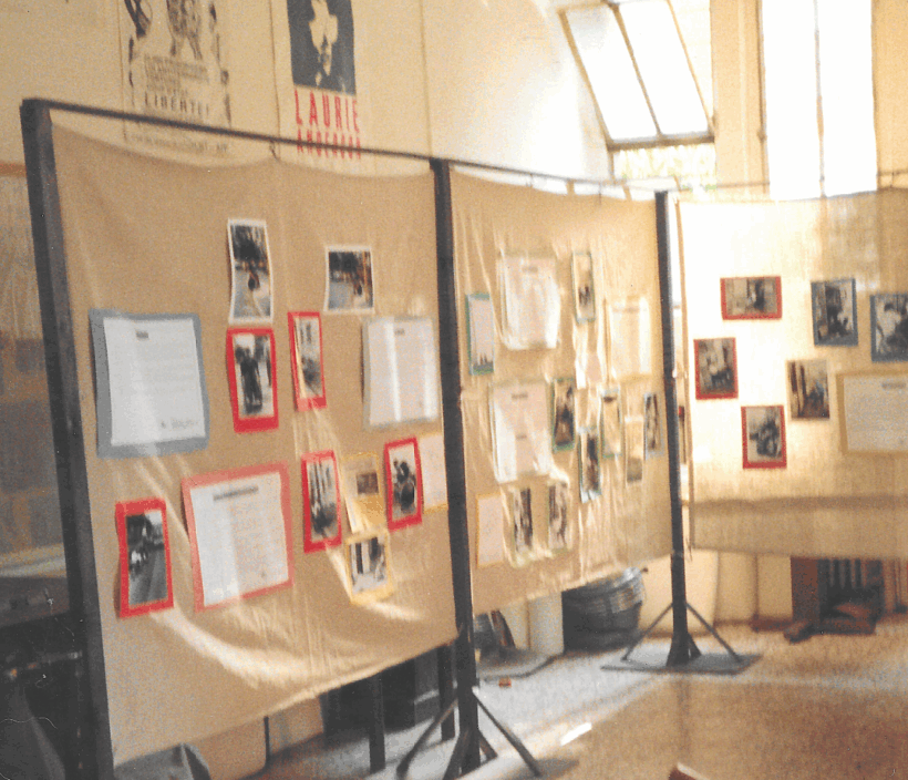 interno con struttura in legno e tela grezza con appese sopra foto e cartelli