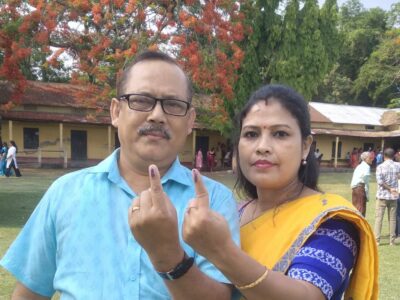 The author and his wife holds up their fingers to indicate that they have voted.