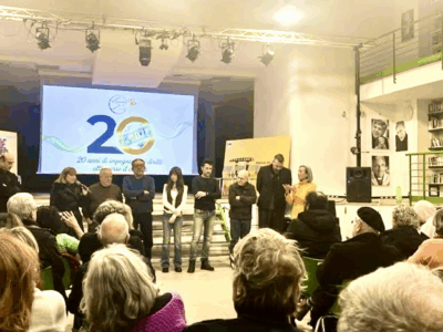 Un gruppo di relatori sul palco dello Spazio Comunale Piazza Forcella, di fronte a un numeroso pubblico. Sullo sfondo, lo schermo con il logo ufficiale dell’evento. L’incontro rientra nella programmazione del XVII Festival del Cinema dei Diritti Umani, con la presentazione del docufilm Sniper Alley – To My Brother.