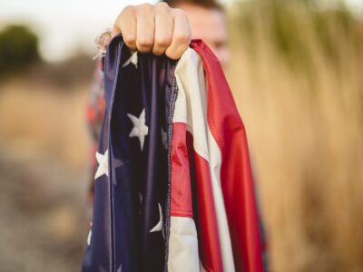 Closeup shot of a male holding the flag of the United States