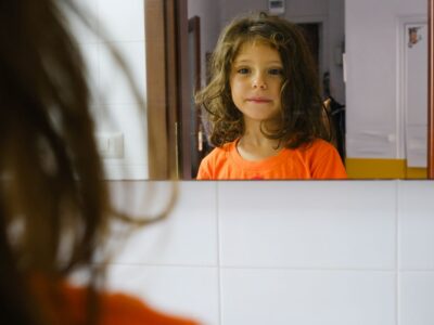 Dede si lava i denti davanti allo specchio, nella sua casa a Napoli. Un gesto semplice e quotidiano, dentro uno spazio protetto. Dal progetto Between Gaza and Naples. A Childhood Story.