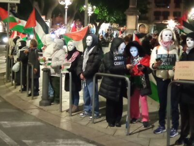 Attivisti pro Palestina, con bandiere e maschere bianche.