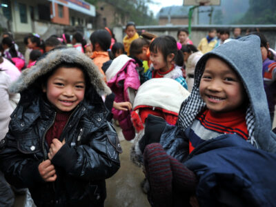 Young students wearing their new clothes pose for photos during a donation ceremony at Hongyan Primary School in Zongdi village, Ziyun county, Anshun city, southwest Chinas Guizhou province, 21 December 2011