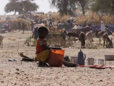 A child tries to find food from a bucket at a displacement camp in El Fasher, North Darfur region, Sudan, on July 9, 2025.