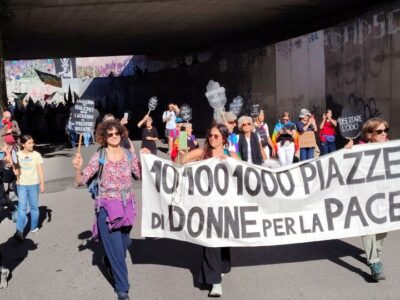 Un momento della mobilitazione “10, 100, 1000 Piazze di Donne per la Pace”: donne in marcia con lo striscione del movimento durante una manifestazione pubblica contro guerra, riarmo e militarizzazione.