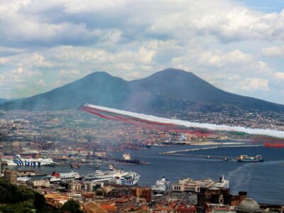 Le Frecce Tricolori sorvolano il golfo di Napoli lasciando in cielo i colori della bandiera italiana, con il Vesuvio sullo sfondo.