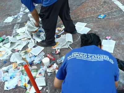 Church cleaners pick up trash, including discarded religious literature, at the patio of the Antipolo Cathedral.