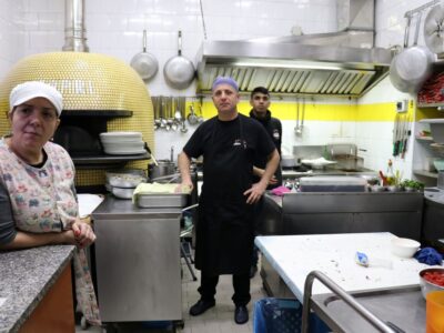 Interno di una cucina professionale con tre lavoratori ritratti durante una pausa o un momento di attività. La fotografia è utilizzata come immagine rappresentativa del contesto lavorativo e non è riferita alla vicenda giudiziaria trattata nell’articolo.