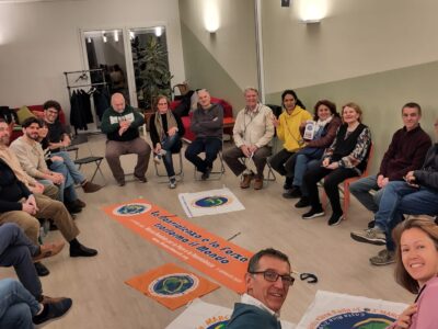 persone i circolo con striscioni e bandiere della Marcia mondiale per la pace e la non violenza