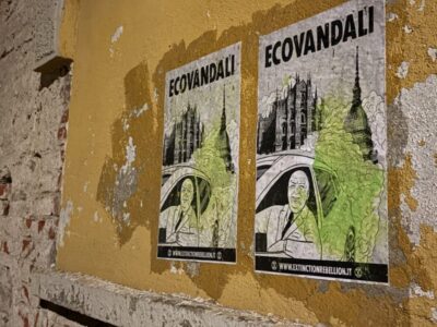 Gilberto Pichetto Fratin che sgasa su un'auto, sullo sfondo la Mole Antonelliana e la scritta a caratteri cubitali: "Ecovandali".